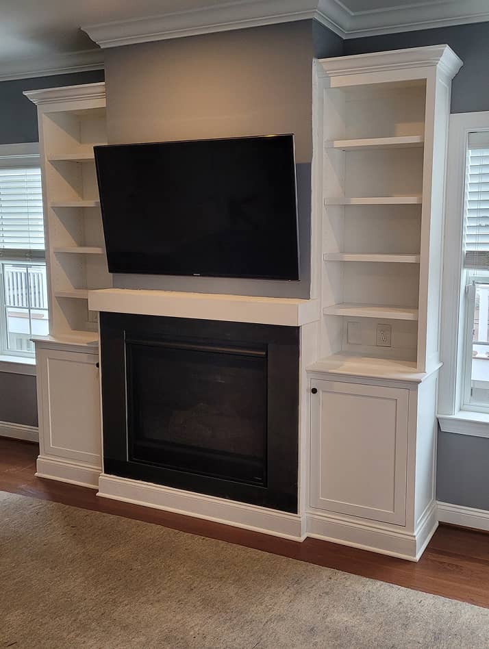 Living room fireplace mantel with storage cabinets