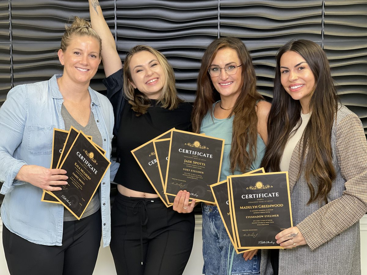 Delta graduates holding their certificates