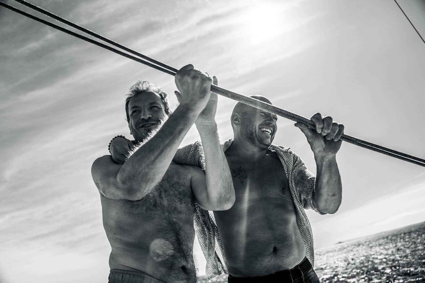 Two guests hauling a line together on the yacht