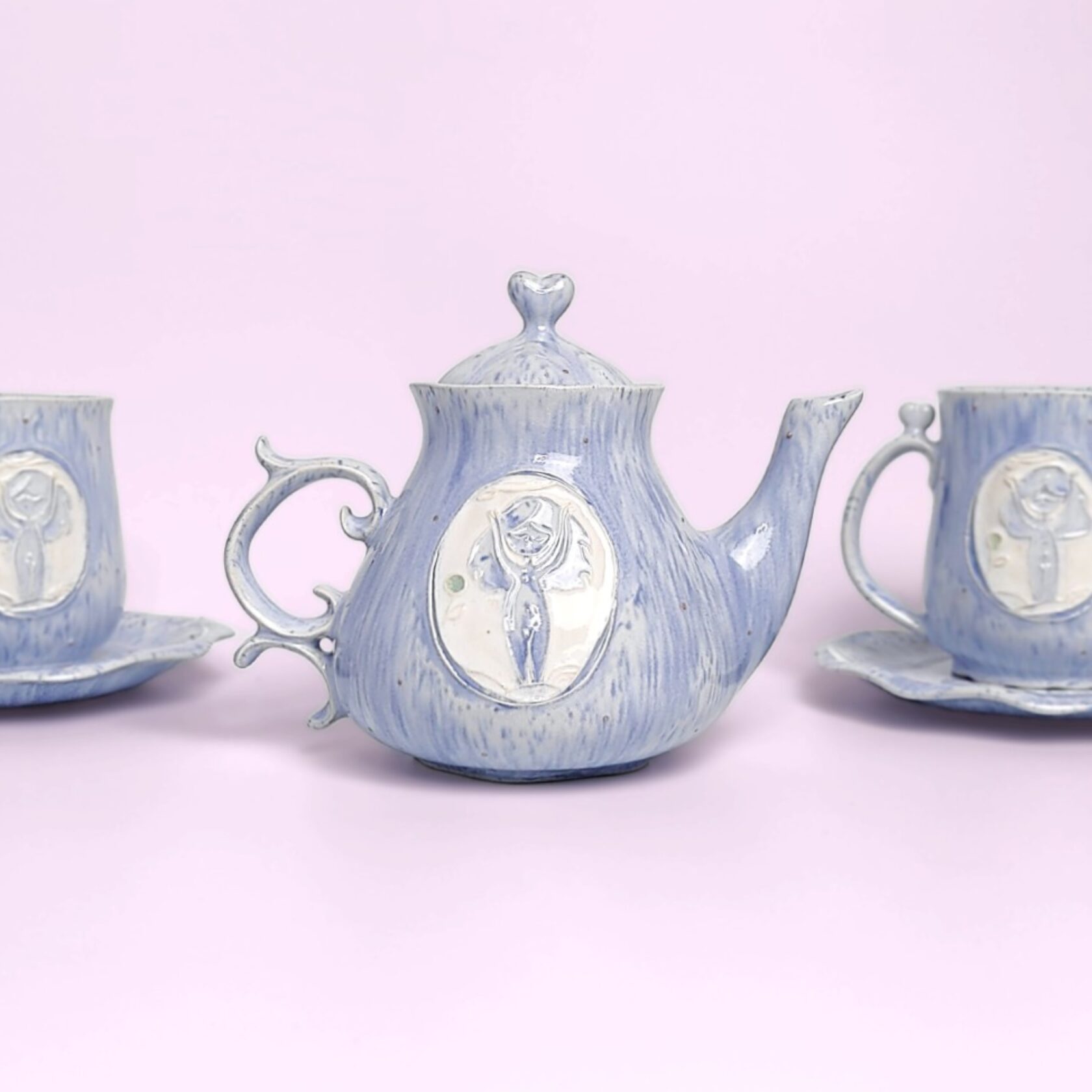 whimsical handmade ceramic tea set in soft blue glaze with forest fairy medallions — an elegant, one-of-a-kind creation