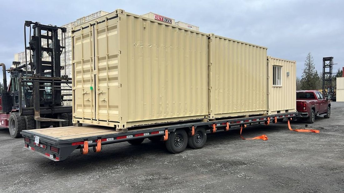 Drybox shipping containers on flatbed gooseneck