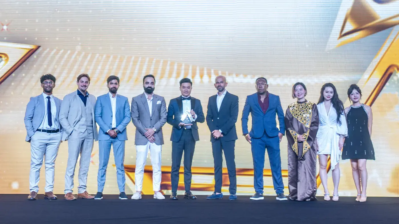 Huaxia Real Estate advisors with a top Dubai broker award trophy