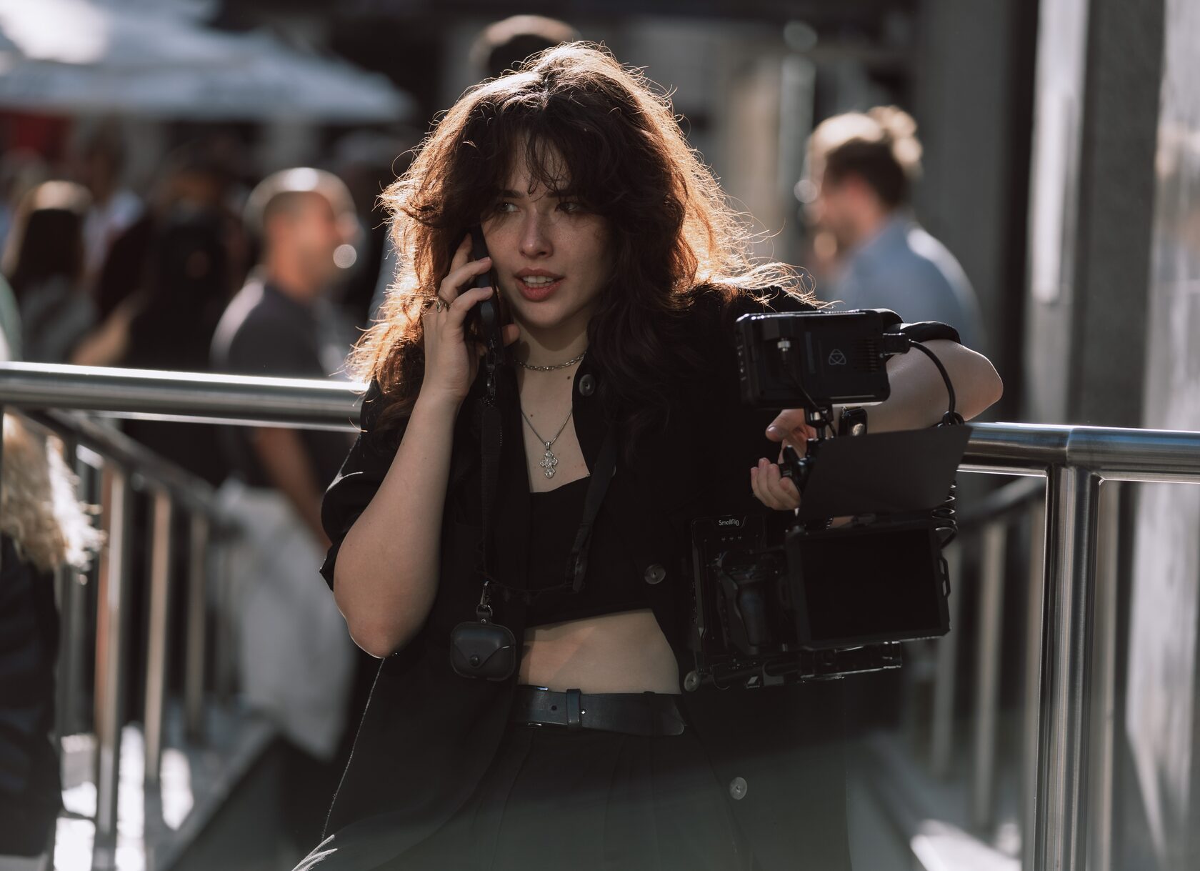 Violetta Coretnic on location in London, a camera rig in one hand and a phone to her ear
