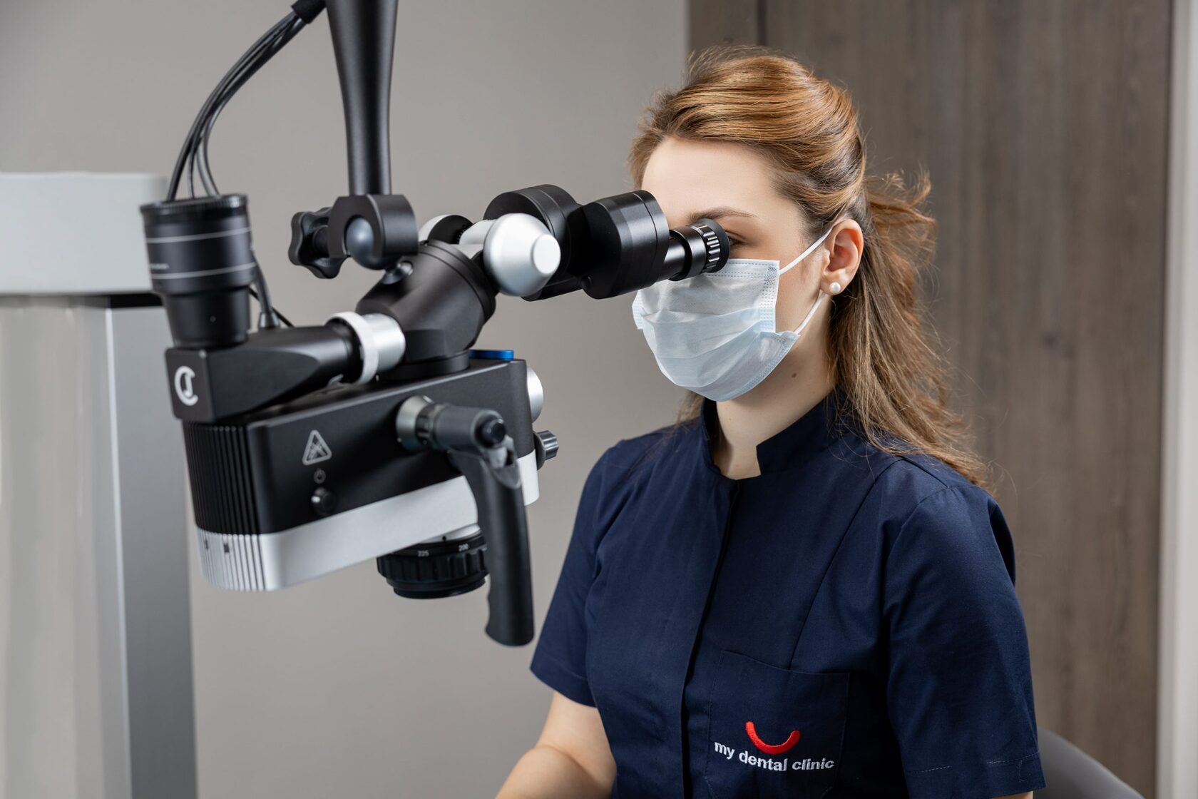 Врач My Dental Clinic работает с дентальным микроскопом