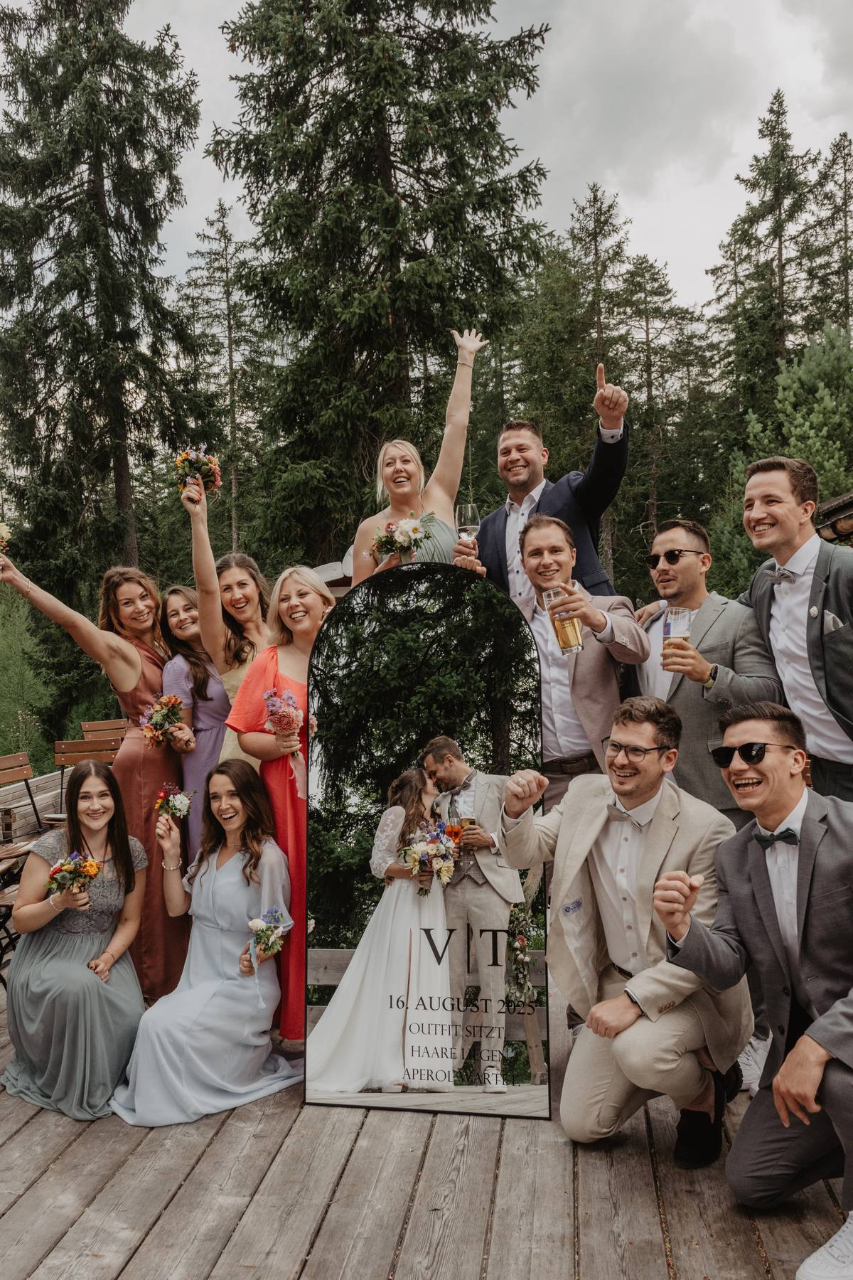 Wedding celebration in the European Alps — bride and groom with guests in a joyful outdoor moment surrounded by mountain forest scenery.