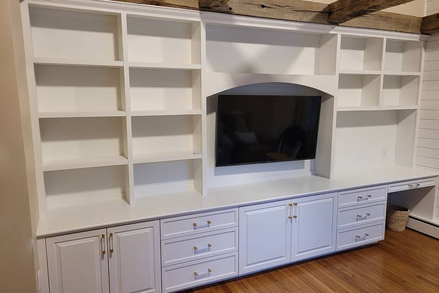 The entertainment center with lower cabinets and upper shelves, and home office built-in