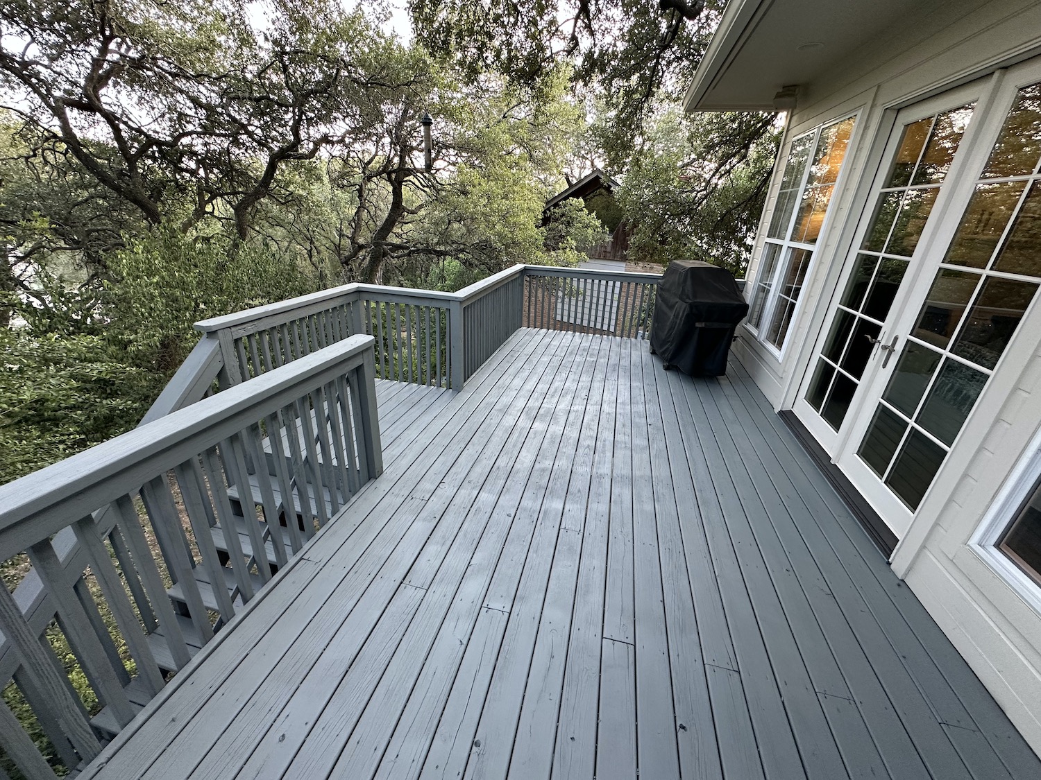 Completed deck restoration in Austin TX — new structural post, sanded surface and two-coat gray exterior paint