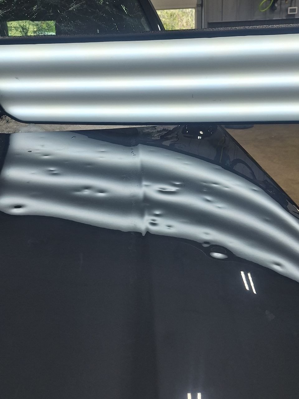 Close-up of hail dents on vehicle panel