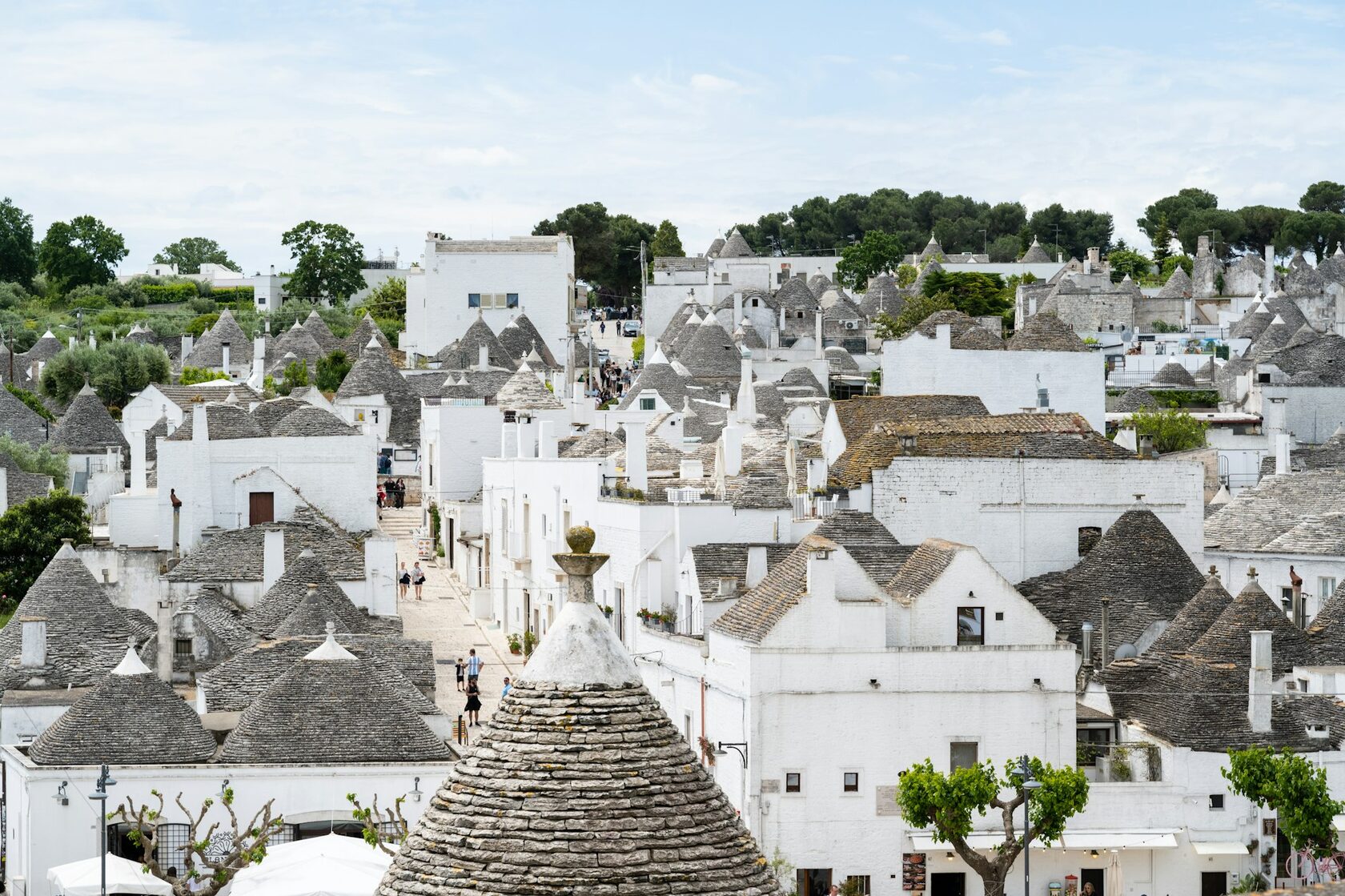 Alberobello's cone-roofed trulli under a clear blue sky