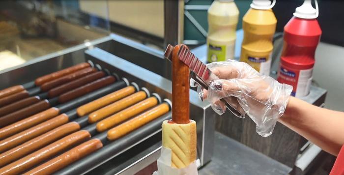 Salchichas en la plancha de rodillos en el punto de venta