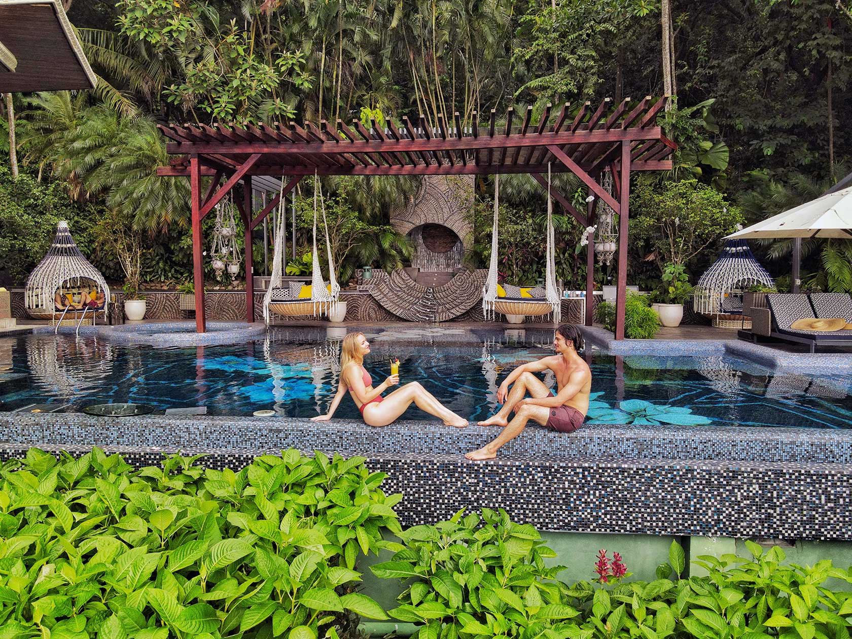 Couple at the edge of the infinity pool at Makanda by the Sea, an adults-only hotel in Manuel Antonio, Costa Rica.