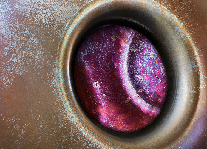 Blick in das Innere einer Handpan mit violett schimmerndem Tonfeld