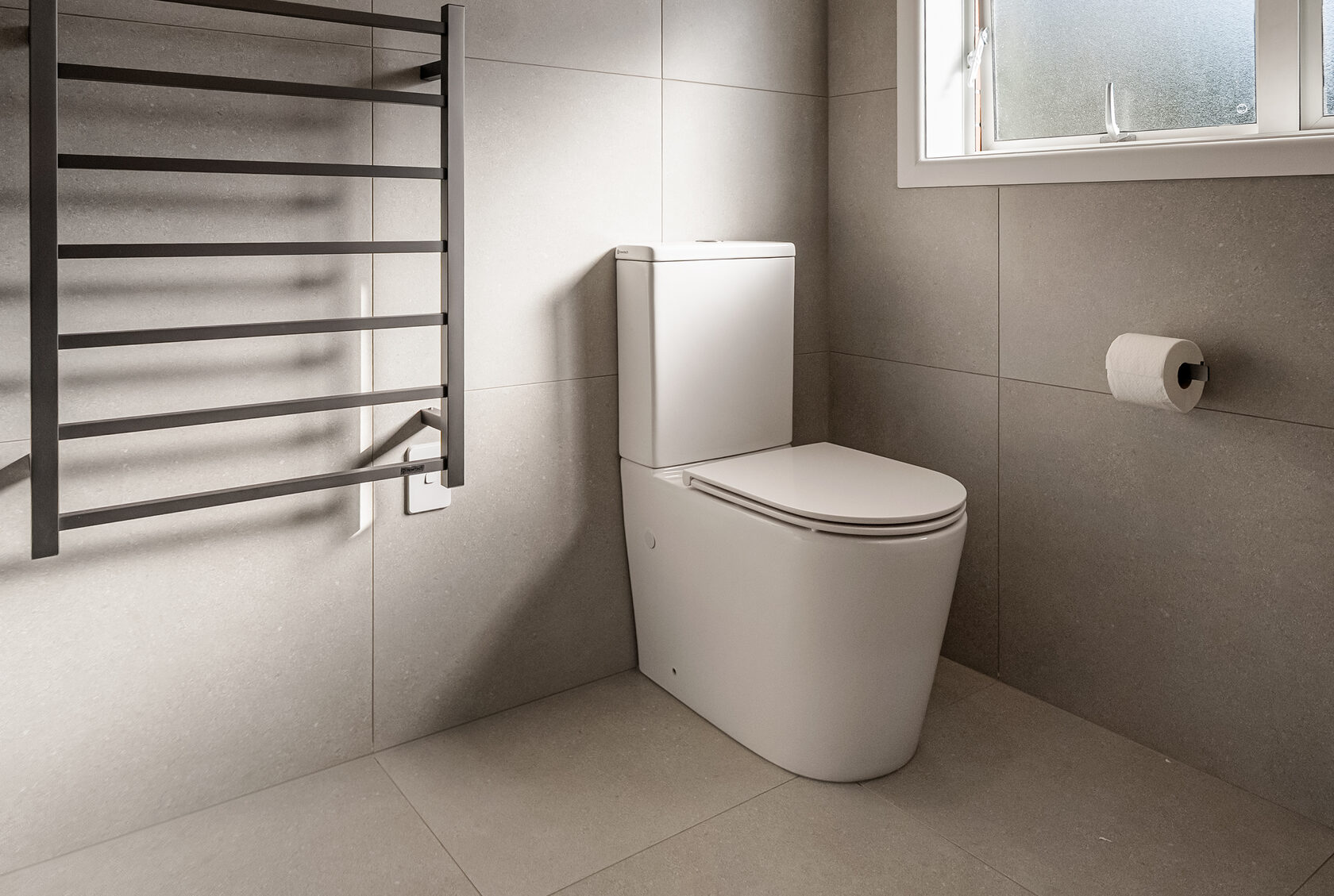 Wall-hung toilet and heated towel rail in the completed Glenfield family bathroom