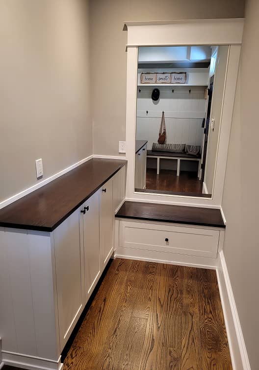 Mudroom storage cabinet with large hall mirror and built-in bench