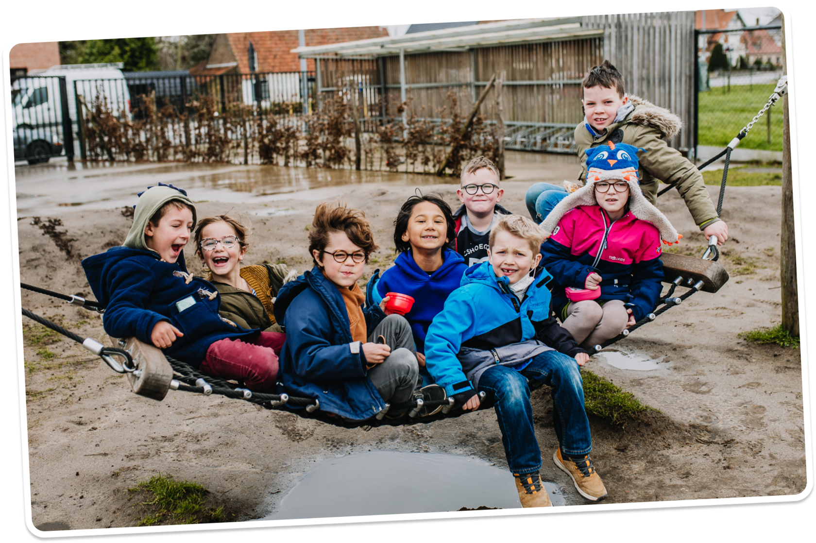 Kinderen op een hangmat bij het zand