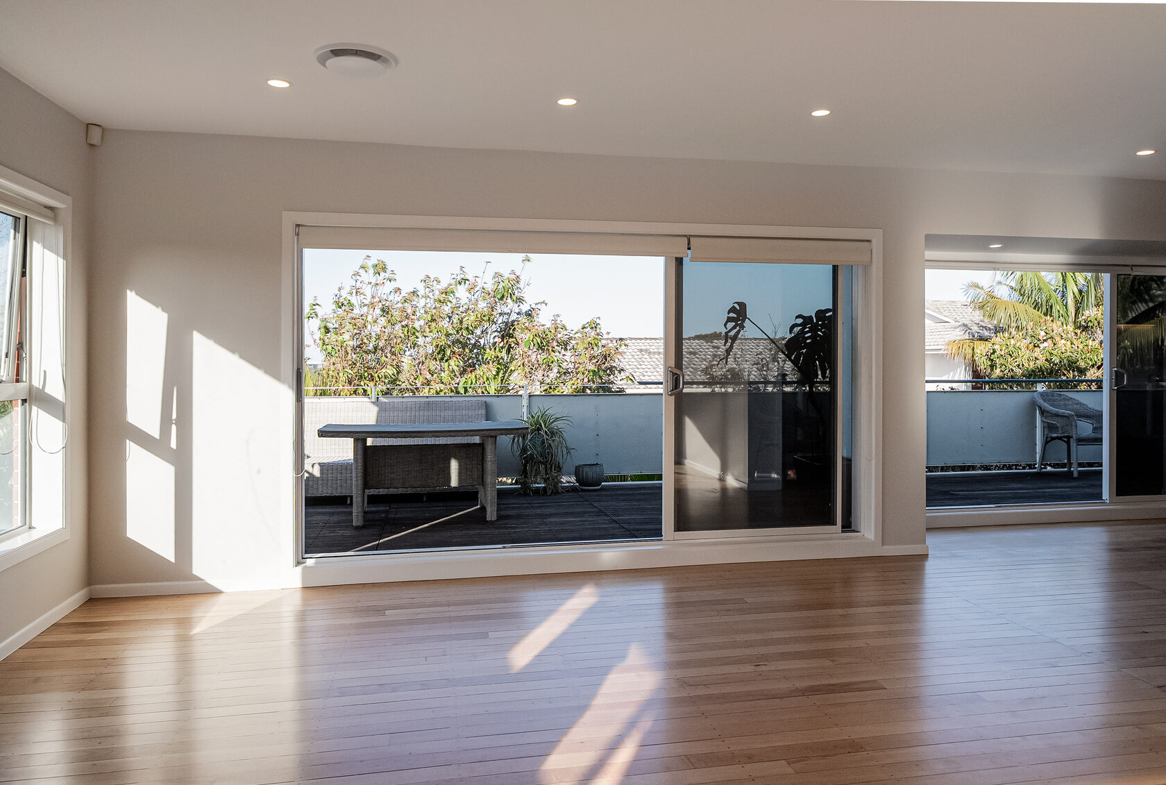 Glenfield dining area opening through wide glazed doors to the outdoor deck