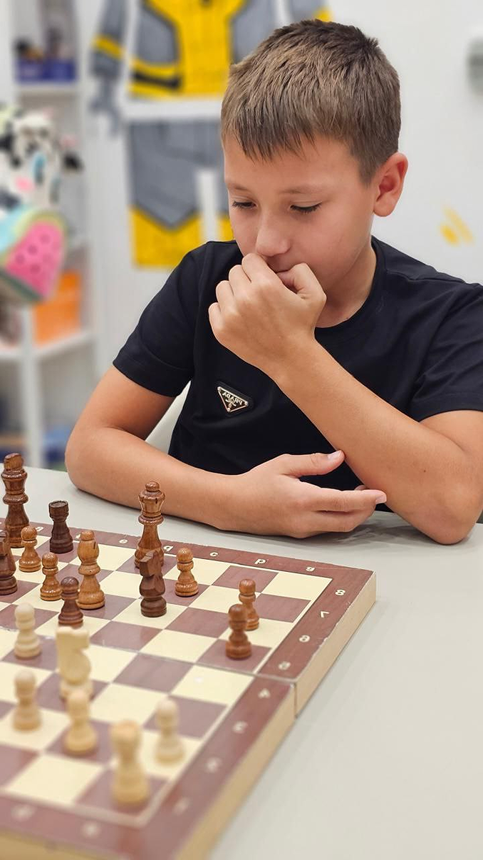 Children at beginner chess level practicing on a chessboard