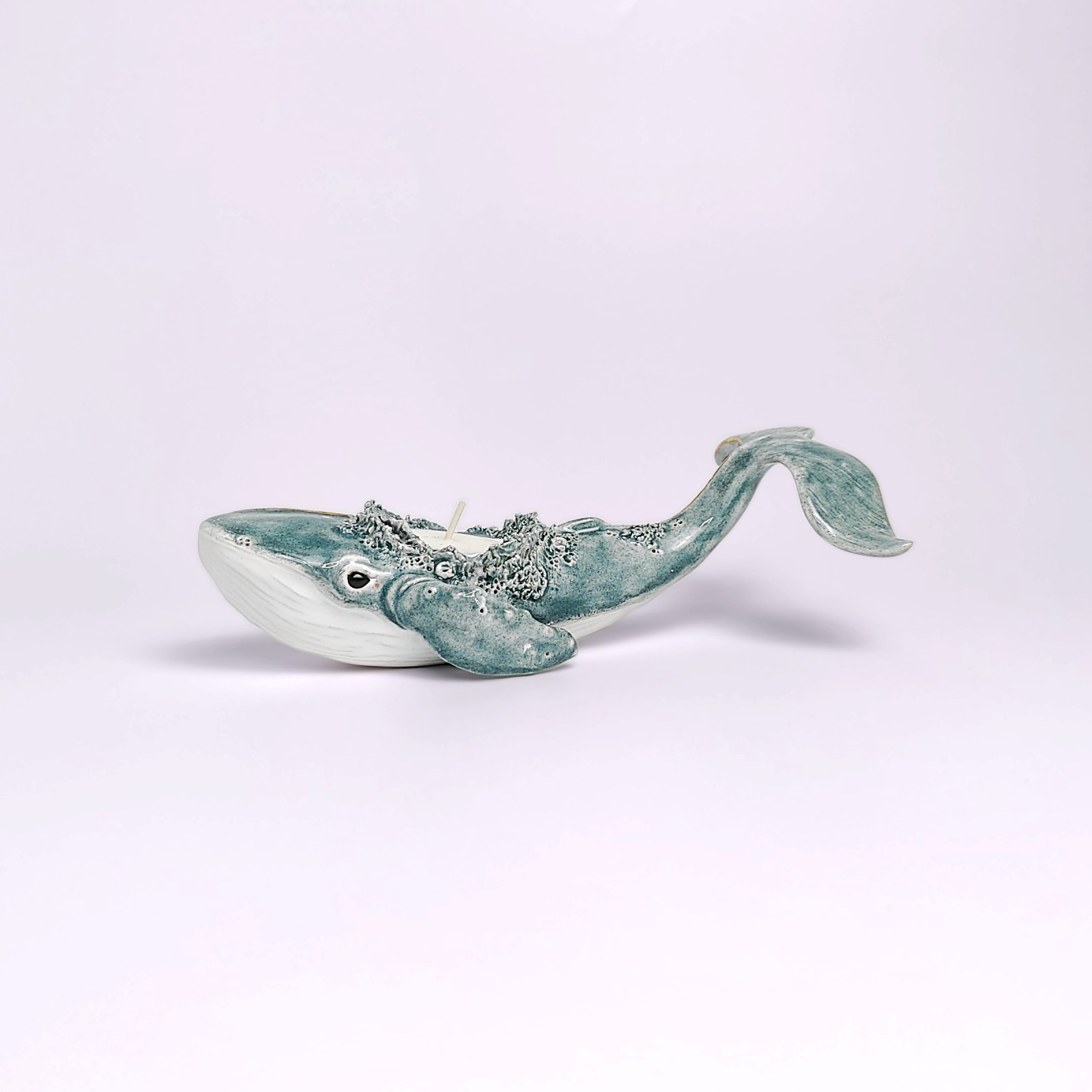 Unique handmade lagoon-colored ceramic whale with detailed sculptural texture and a built-in candle, inspired by ocean forms