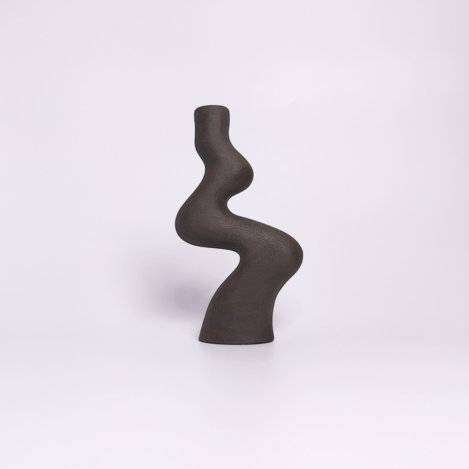 minimalist black handmade ceramic candle holder for a single candle, crafted in an elegant organic curved shape
