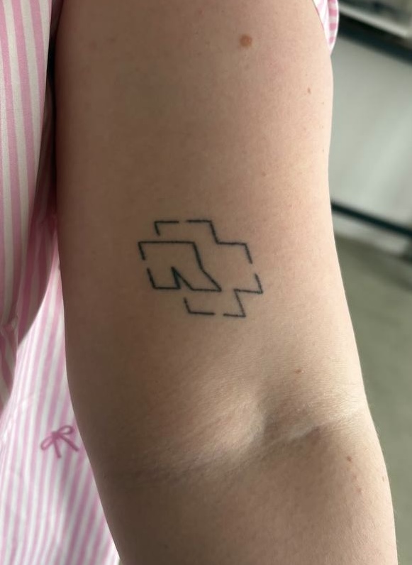 Kleines Rammstein-Logo-Tattoo am Oberarm vor dem Cover-Up