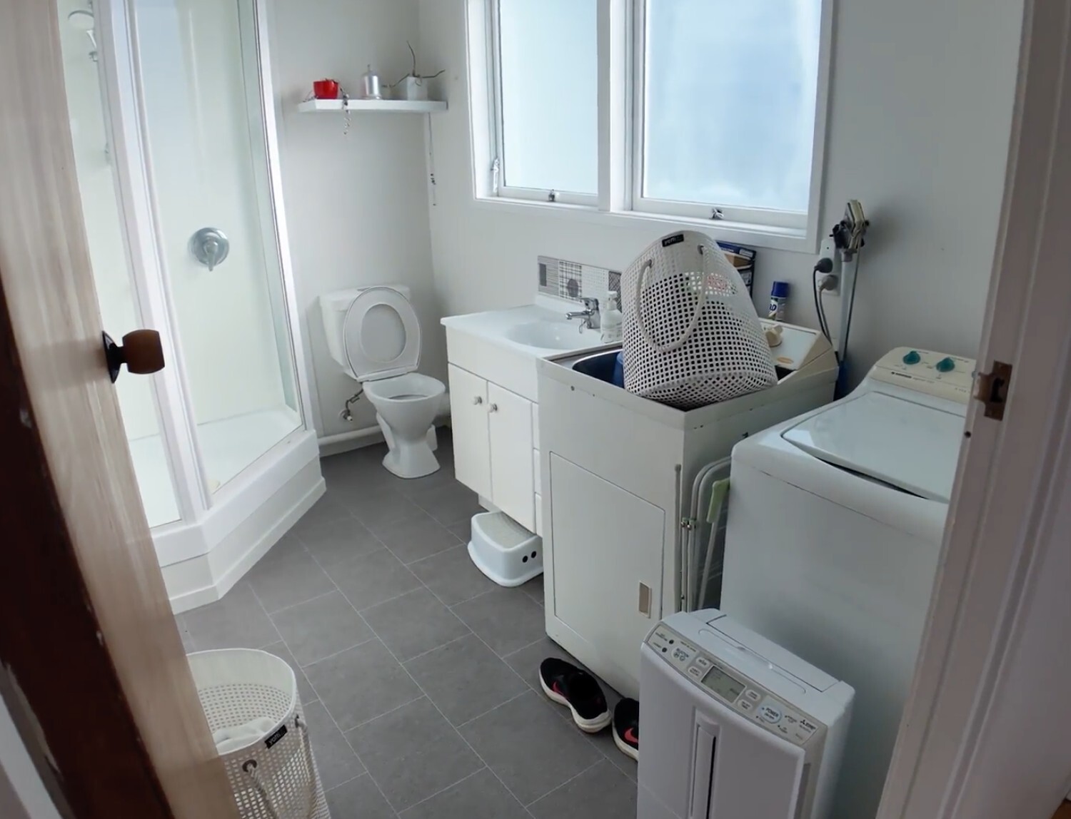 Before: compact Hillcrest bathroom and laundry with shower, toilet, vanity and washing machines