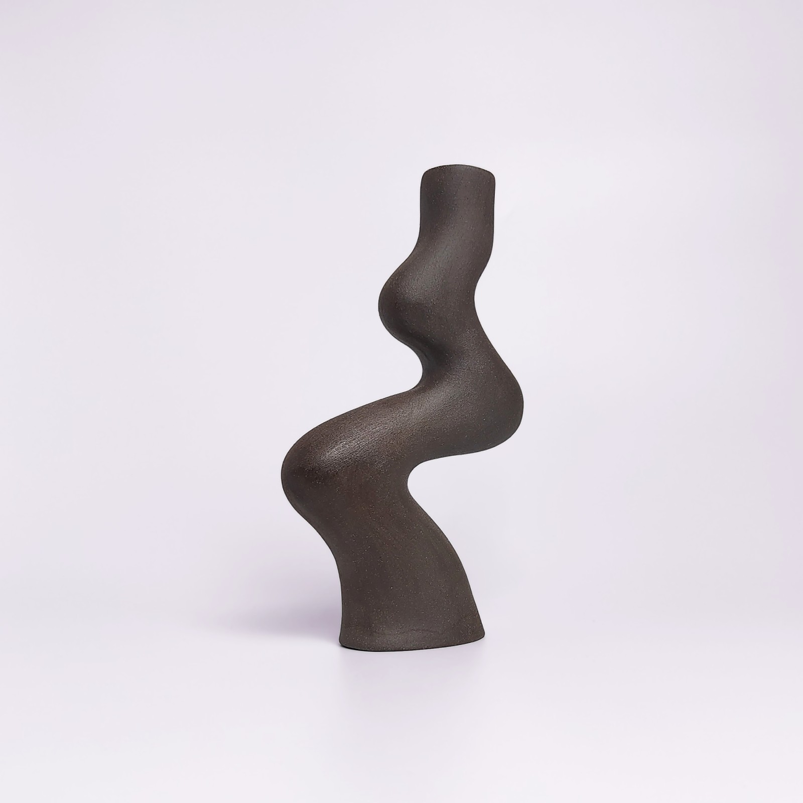 minimalist black handmade ceramic candle holder for a single candle, crafted in an elegant organic curved shape