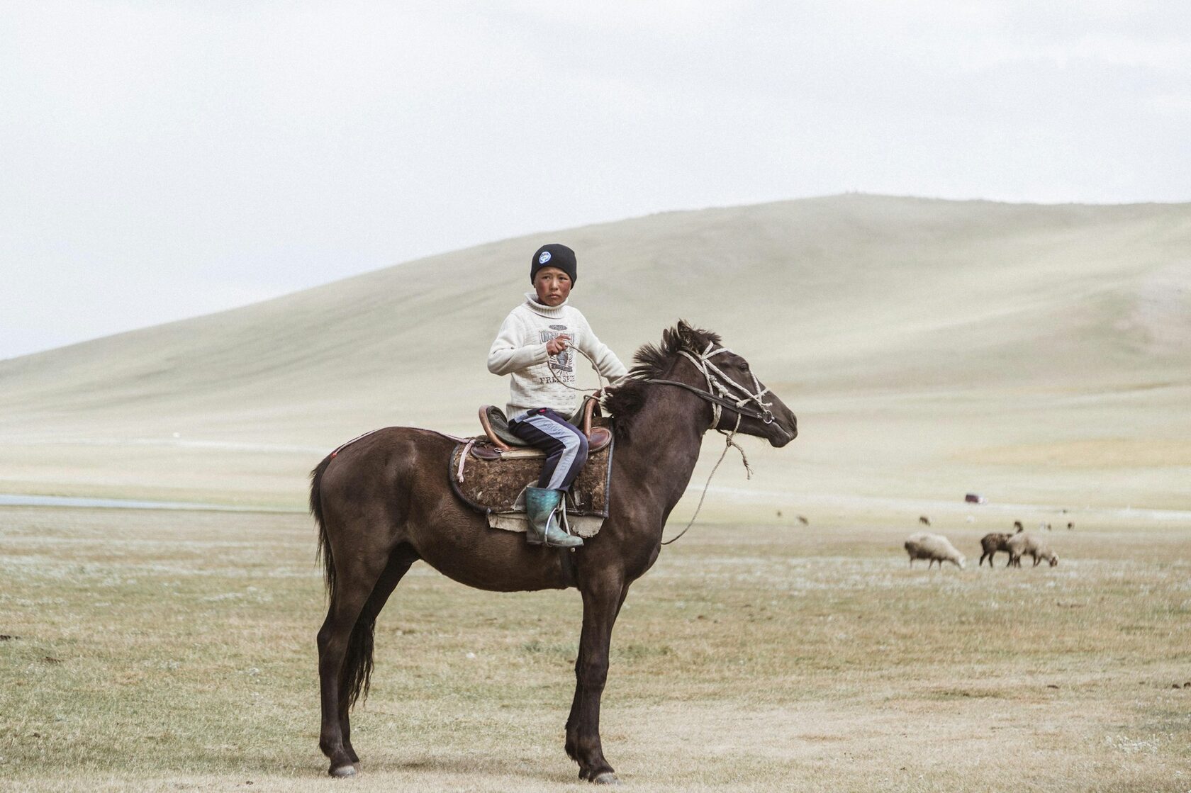 Riders on horseback crossing a high mountain pasture in Kyrgyzstan