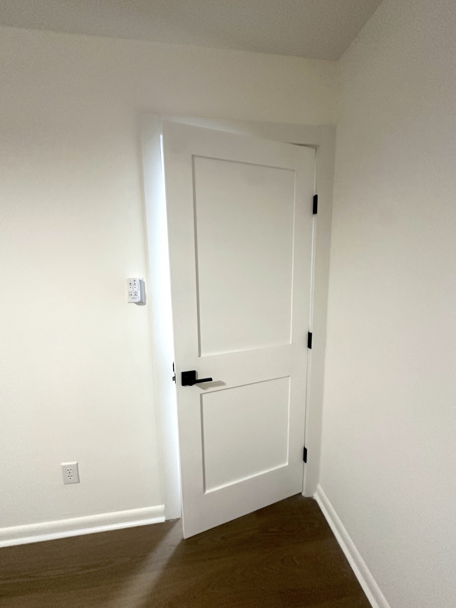 New white interior door with black lever hardware and finished trim