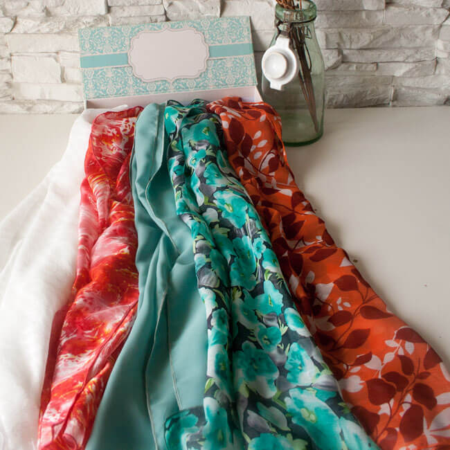 Различни цветове дамски шалове в луксозна кутия за подарък с място за надписване.