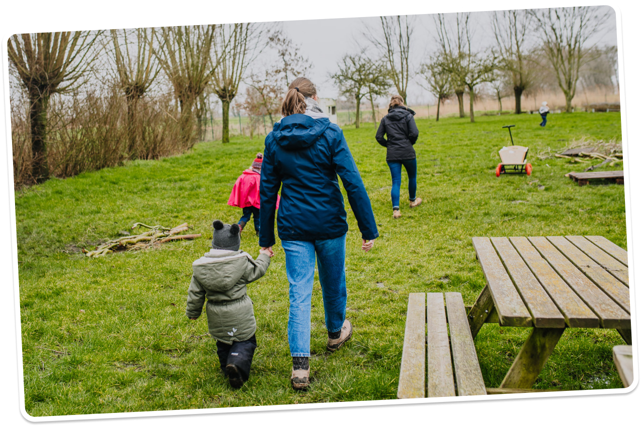 Leerkracht met leerling in de tuin