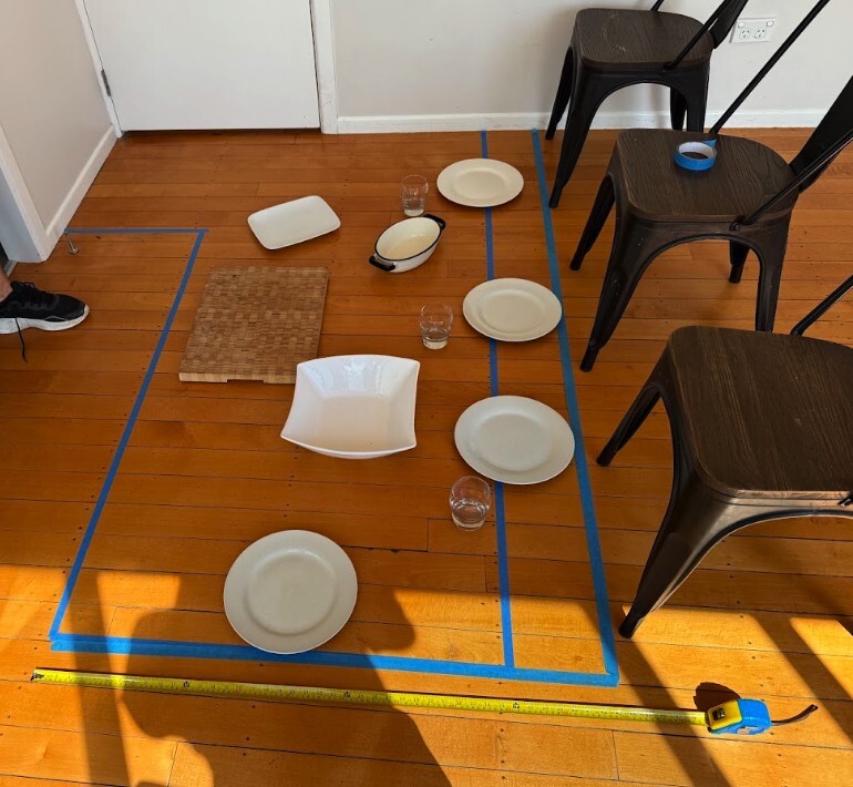 Kitchen island position marked with tape, chairs, plates and glasses before installation