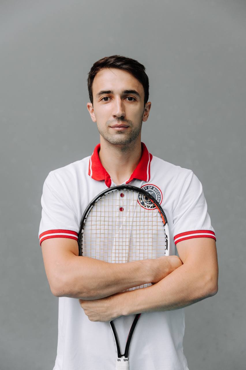 Coach Artem holding a tennis racket