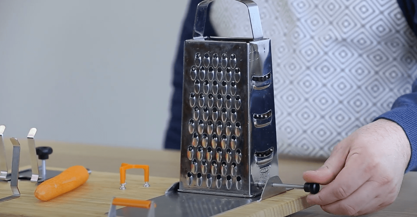 Grater secured with the grater holder on the adjustable attachment on the one hand cutting boards for disabled.