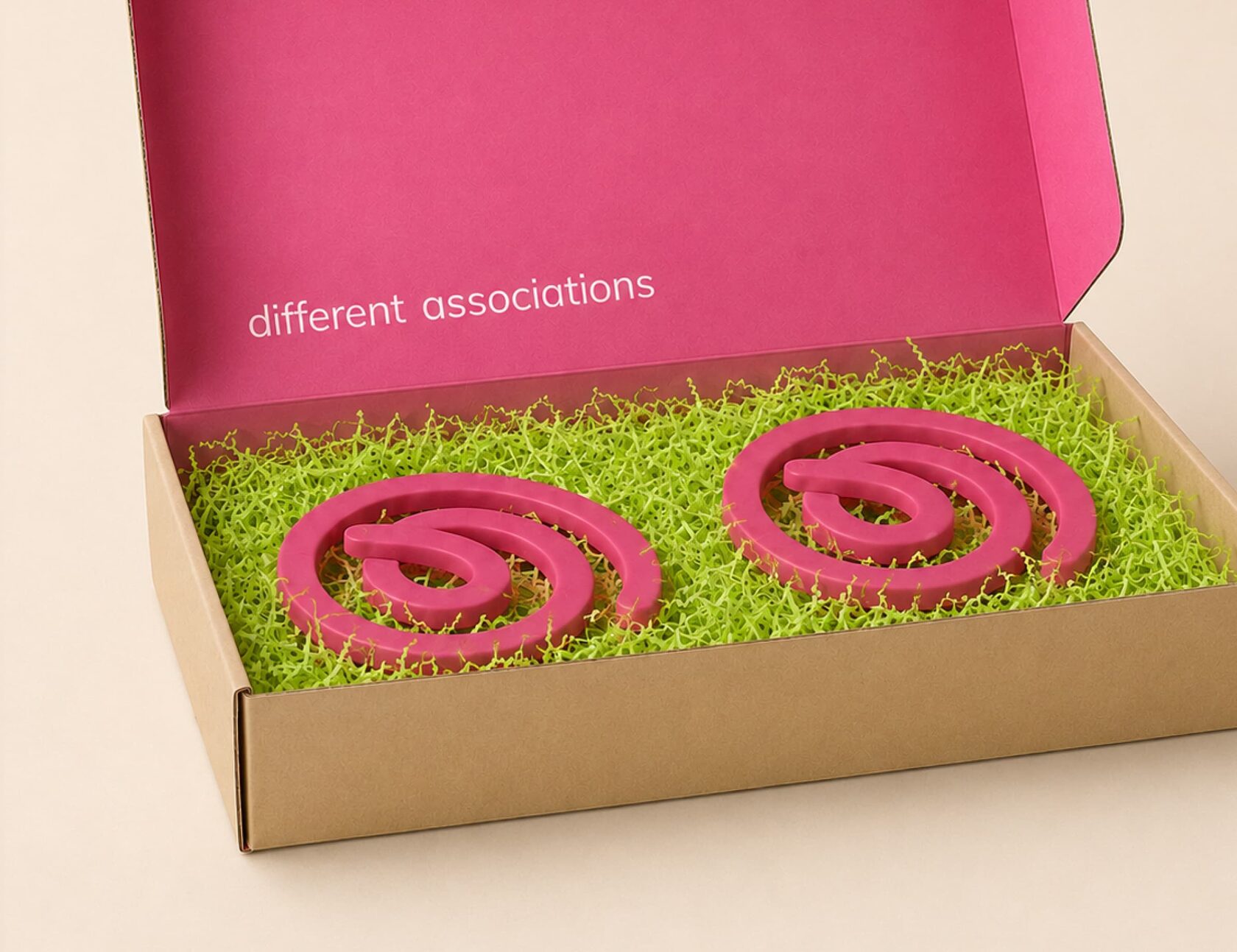 Open gift box with pink coils and green paper