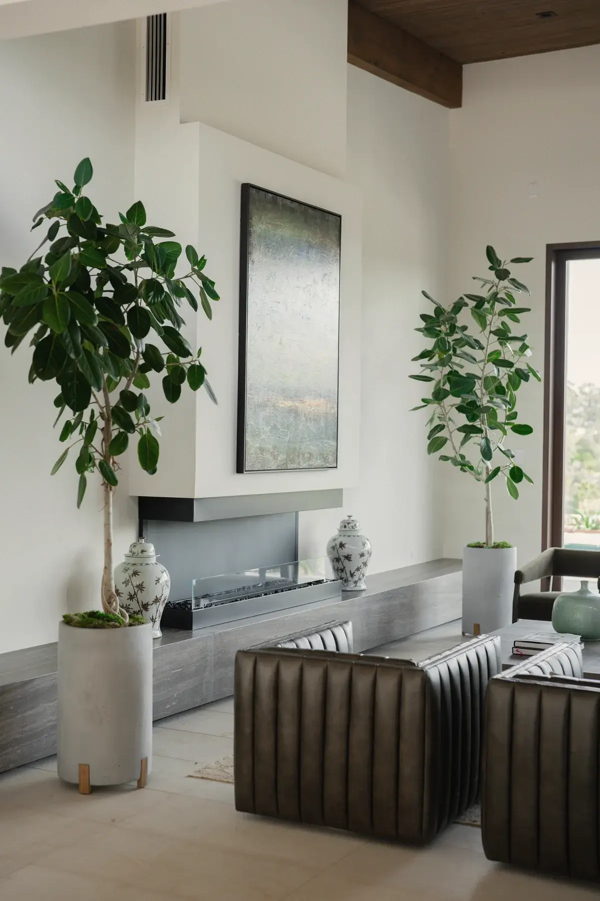 A pair of indoor trees flanking a fireplace