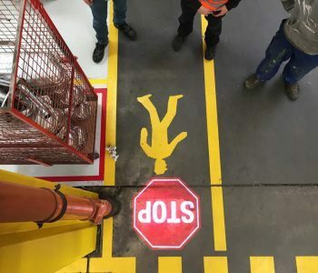 Projected safety sign and floor marking in a warehouse aisle