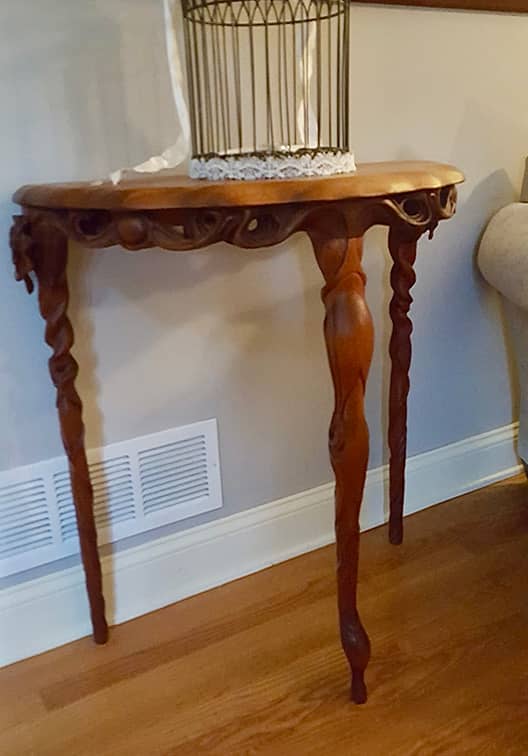 Three legged hand carved hall table with floral detail 