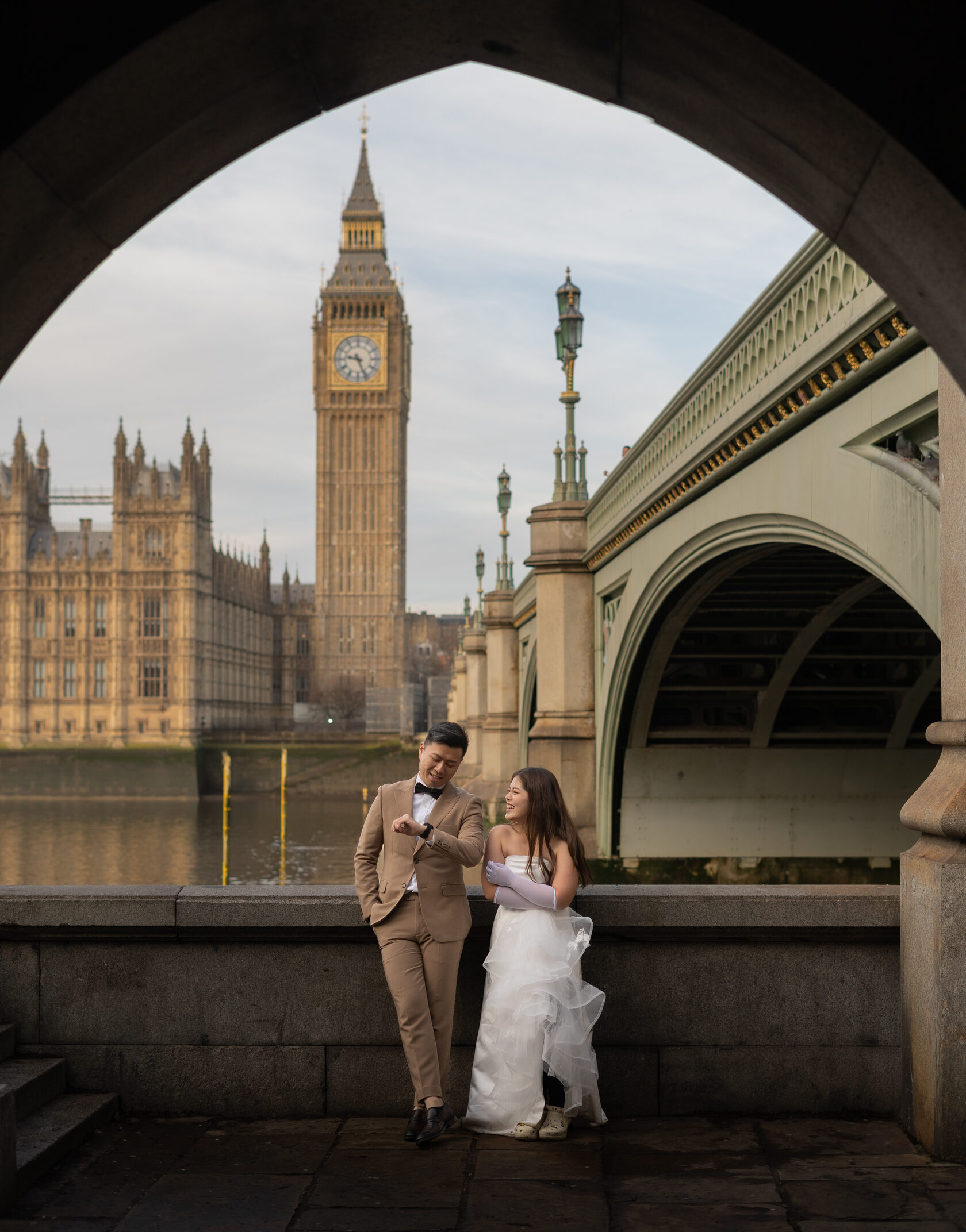 A couple beneath the Westminster Bridge arch with Big Ben in view
