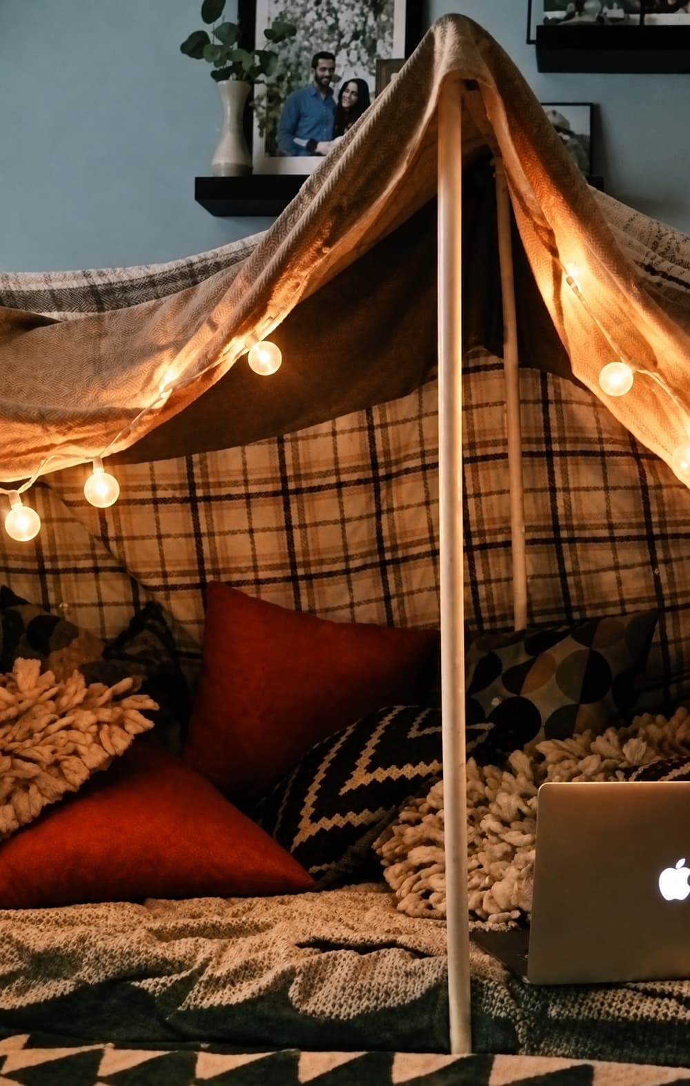 A small blanket fort with cushions and lights