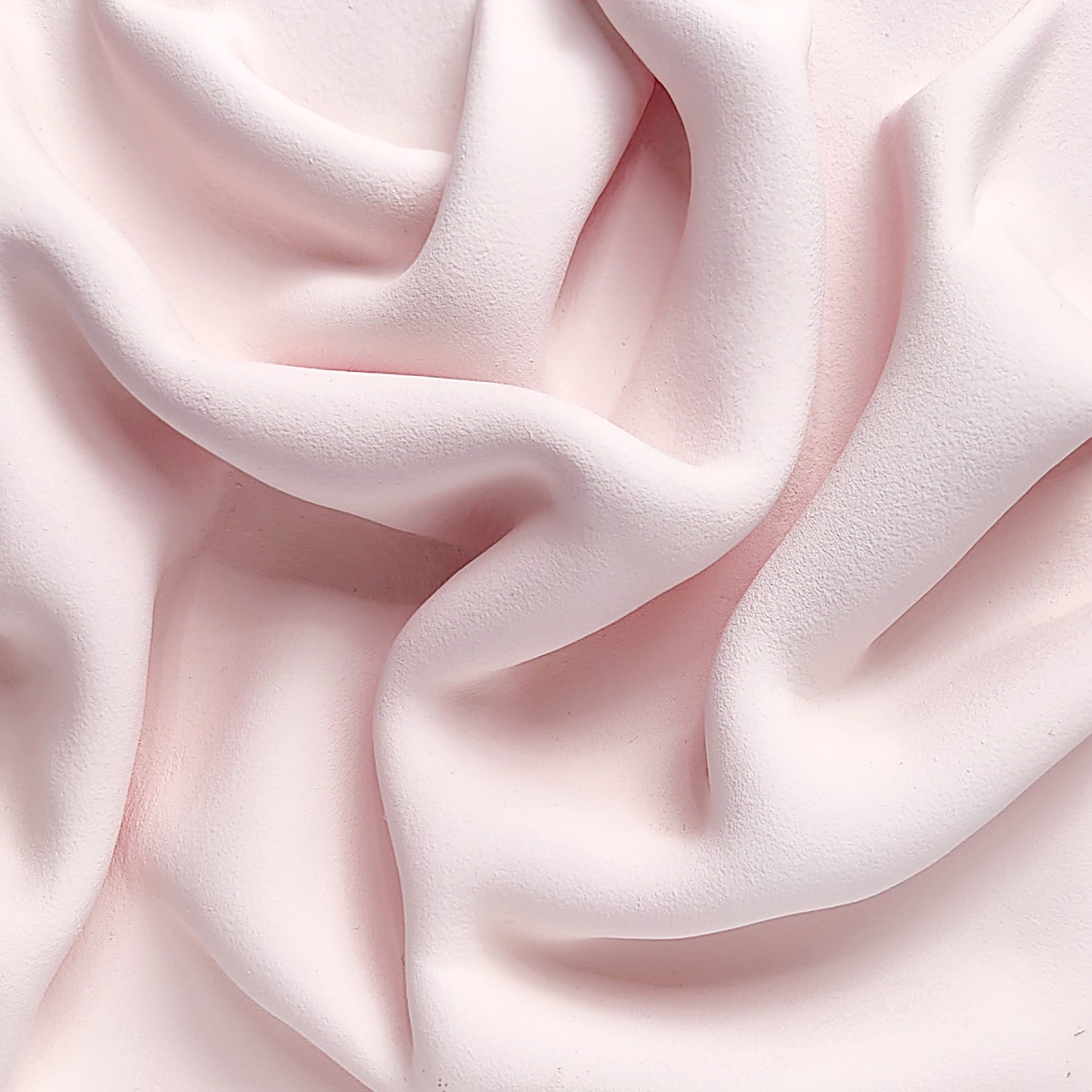textured wall art made of air-dry clay in a soft pink shade with flowing sculpted drapery