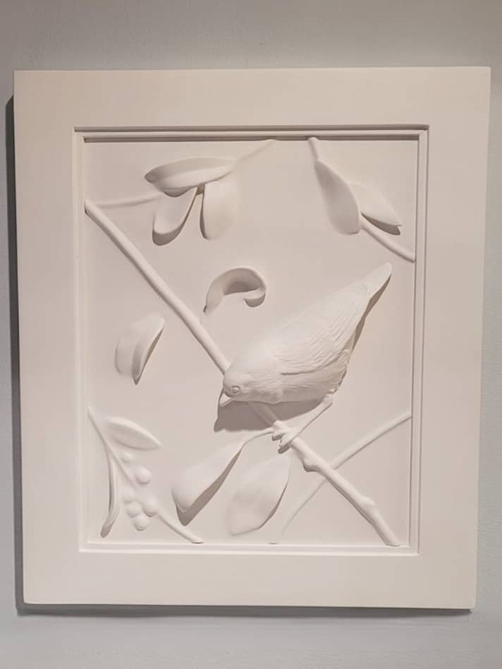 Decorative white wall plaque of bas relief of warbler on a branch