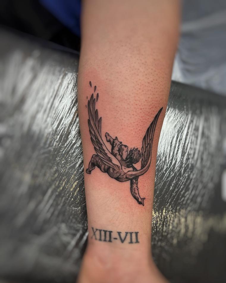 Detailed cherub tattoo on inner forearm