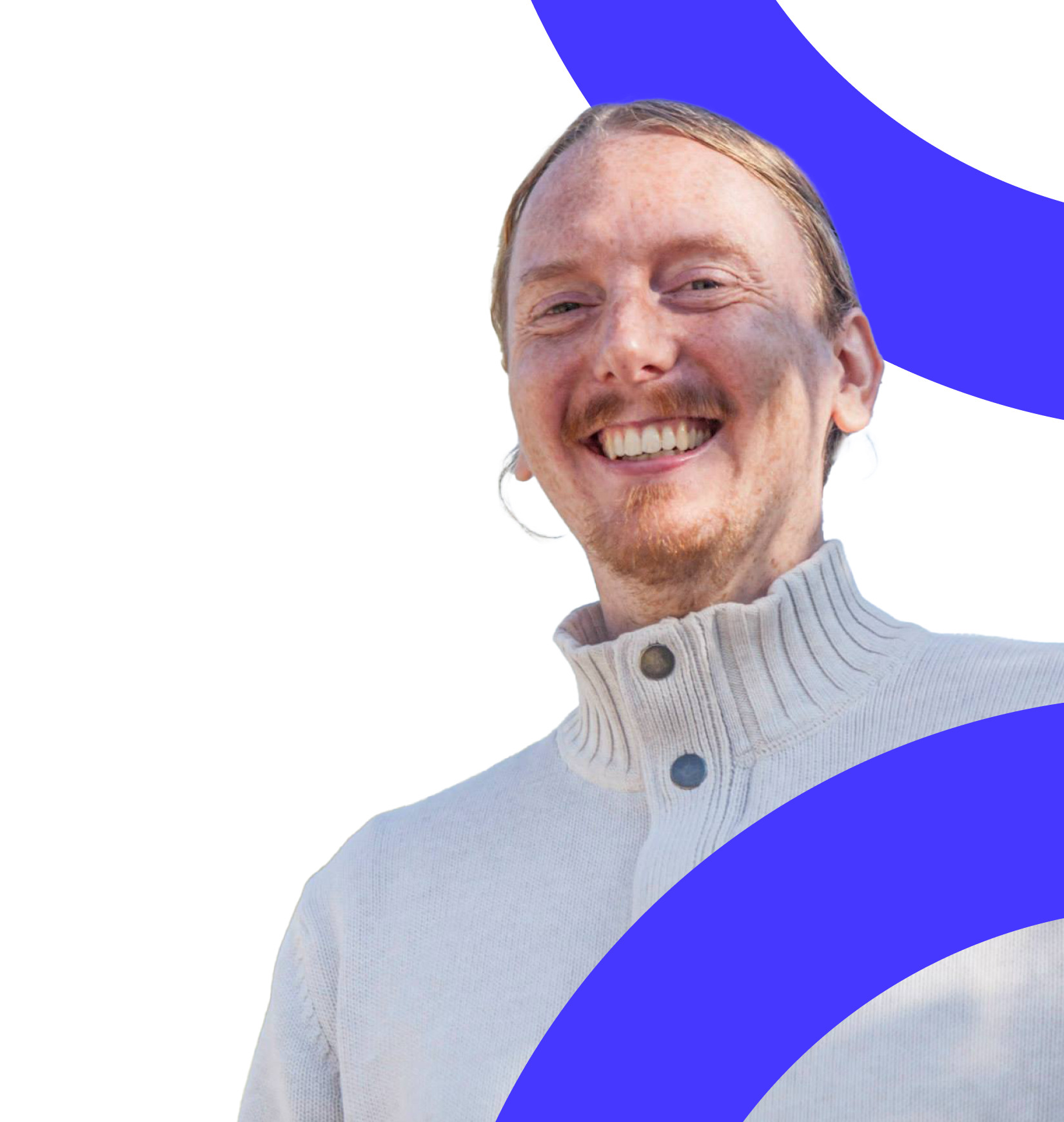 A man (David Backeus) in a white sweater is smiling widely.