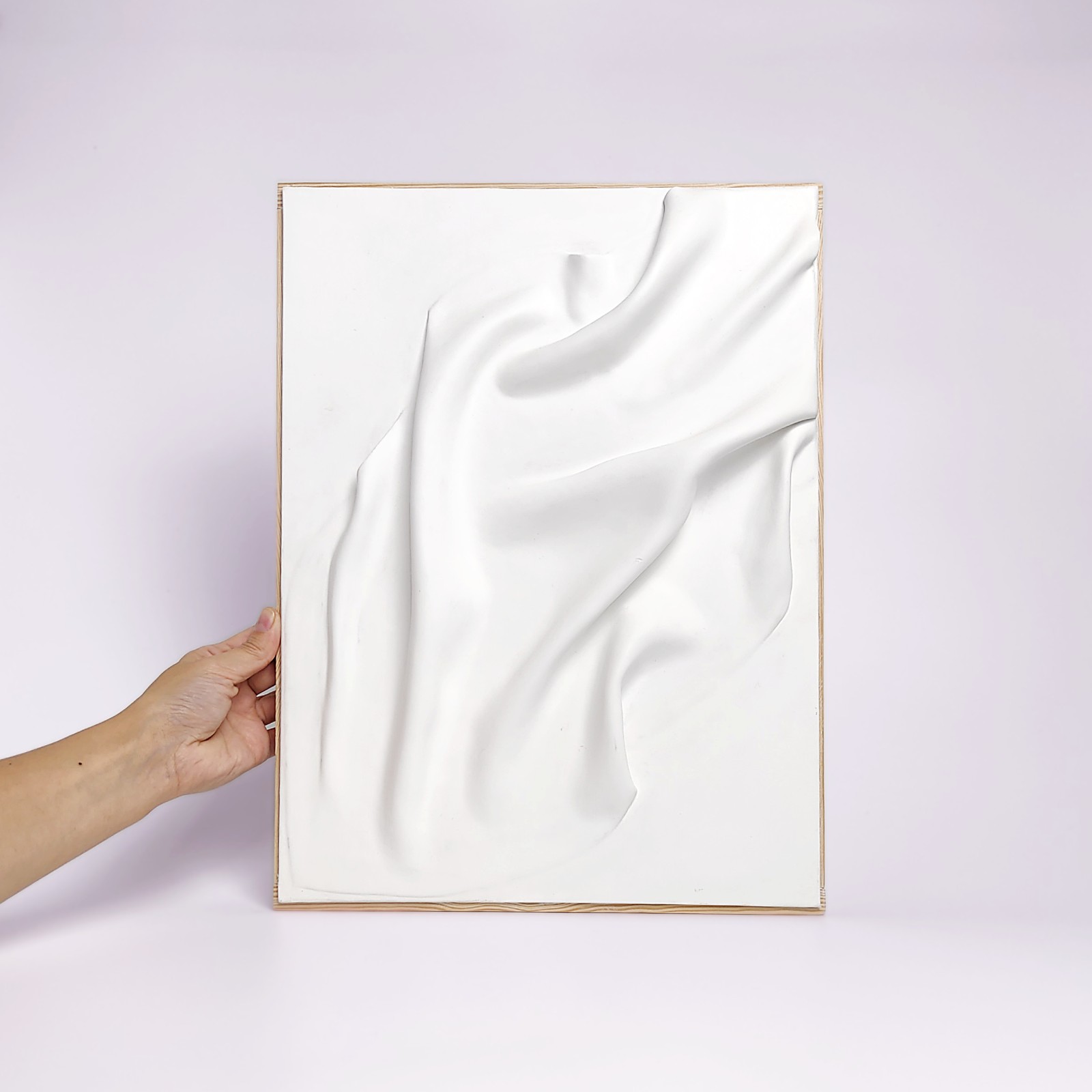 Unique handmade wall art crafted from air-dry clay, featuring minimalistic flowing sculptural drapery in a soft white finish