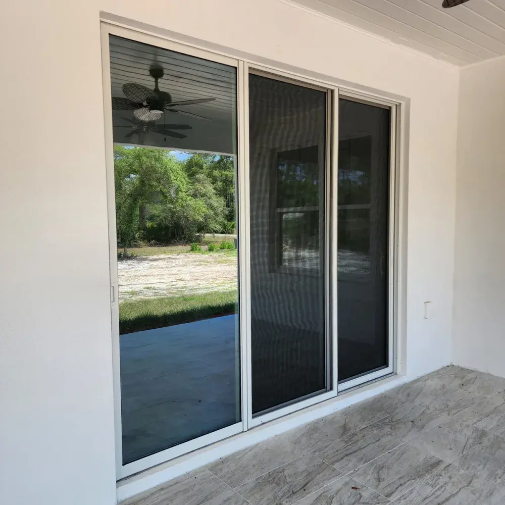 Sliding screen door gliding on a patio track