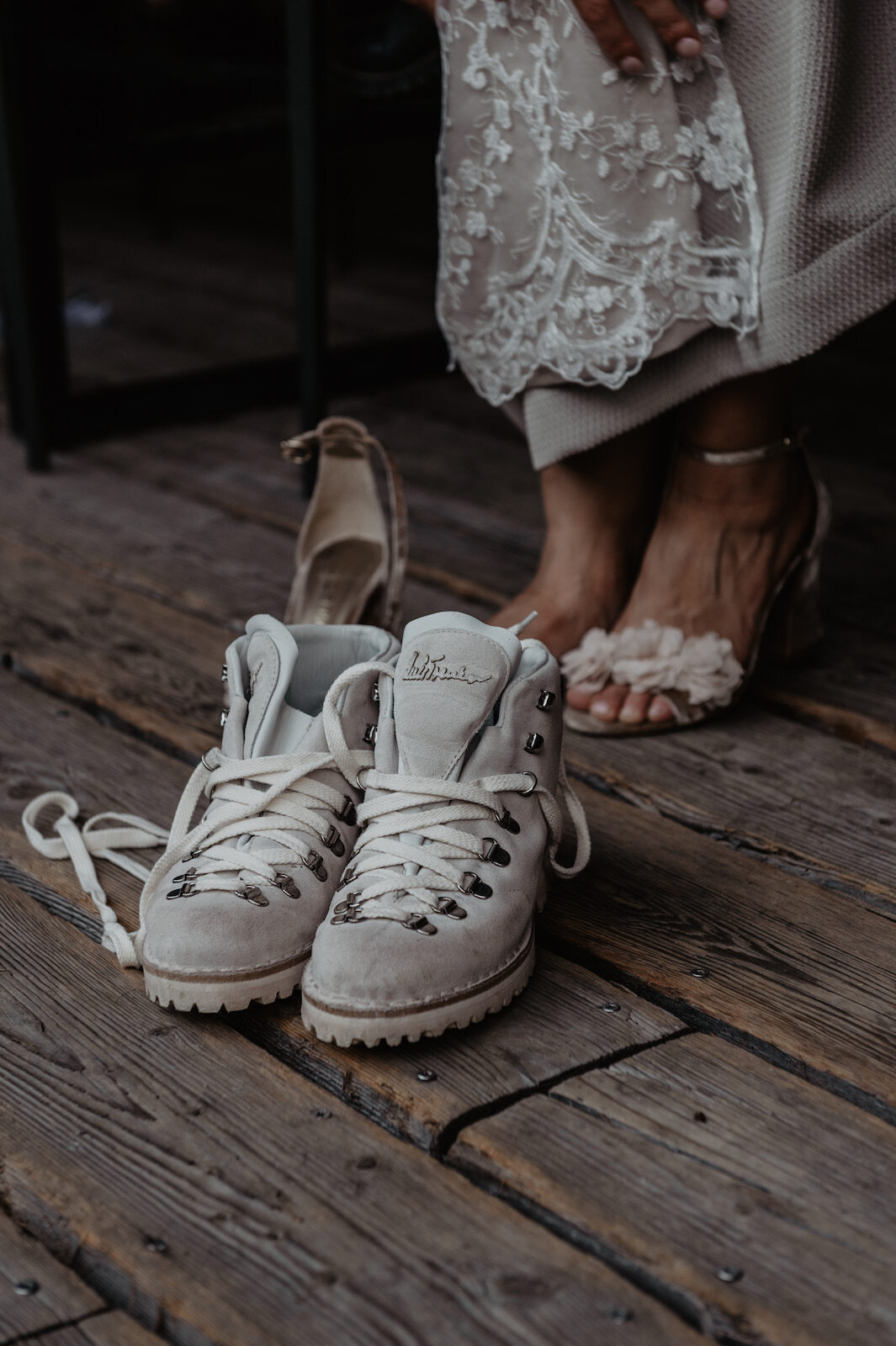 Elopement details in the Alps — contrast between hiking boots and bridal heels showing the blend of adventure and elegance.