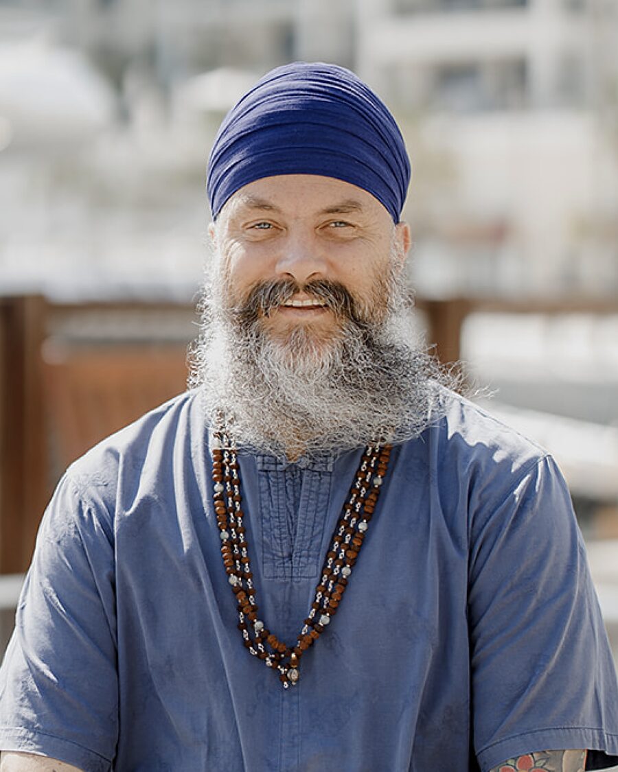 Jugat Guru smiling, in a blue turban and wooden beads