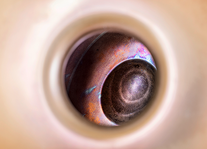 Nahaufnahme in das Innere einer Handpan in warmen Metalltönen