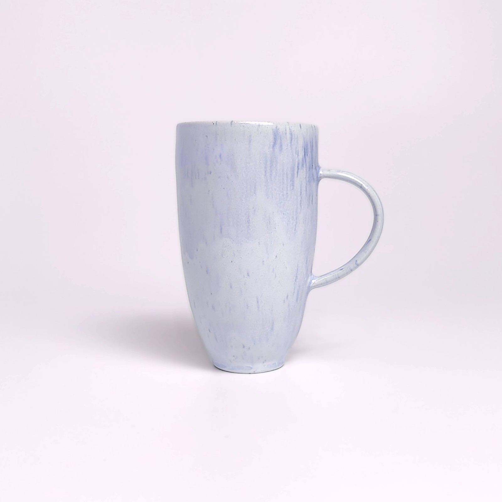 Unique handmade light blue ceramic mug with a pastel glaze, adorned with a sculpted medallion of a cute bear in a red scarf