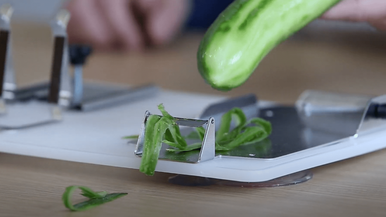 Peeling cucumber using peeling blade with which is equipped adjustable attachment on the one-handed cutting board.